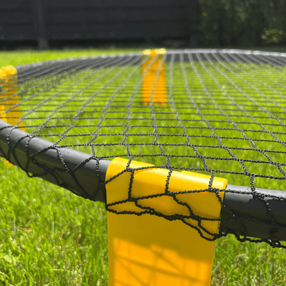 Vue en angle du filet Roundnet avec poteau jaune et maille noire tendue