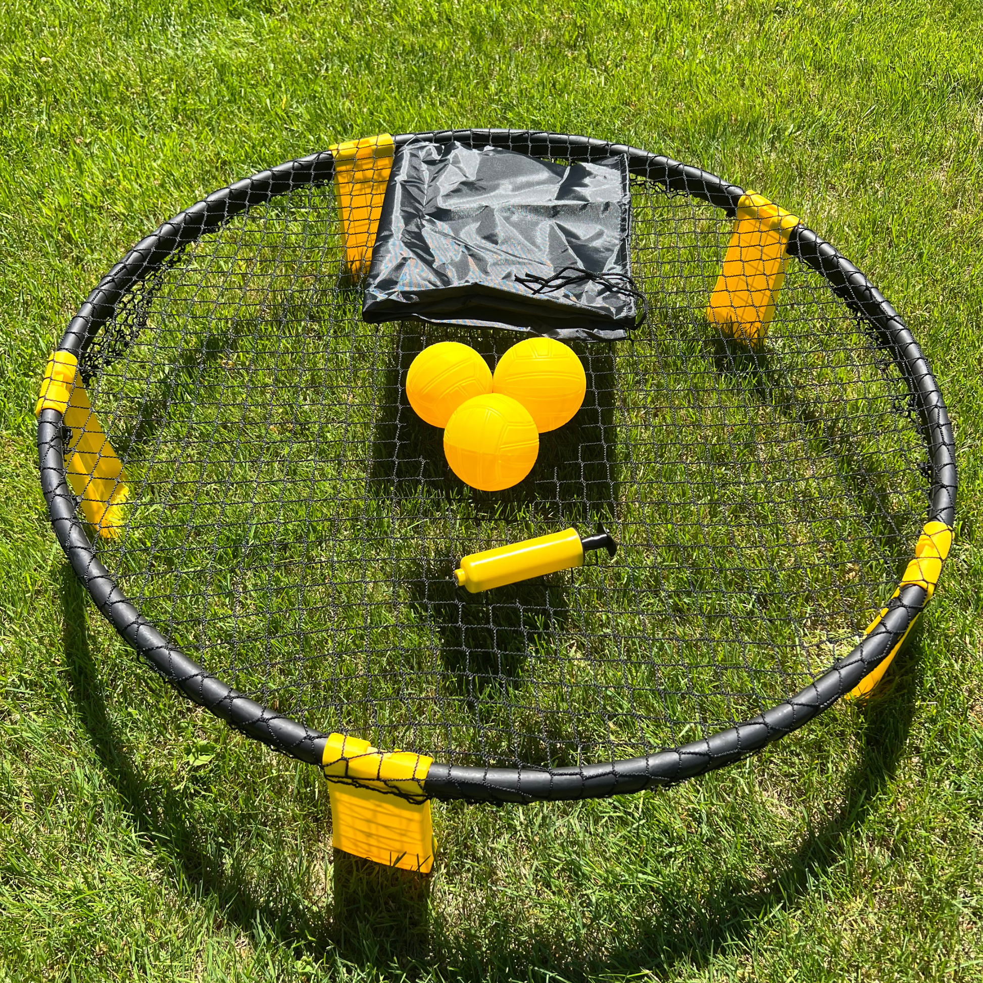 Set Roundnet complet avec filet circulaire noir et balles jaunes sur gazon