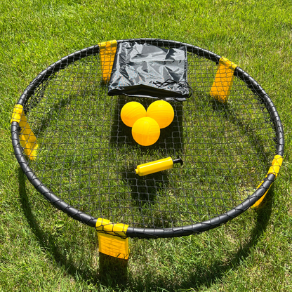 Set Roundnet complet avec filet circulaire noir et balles jaunes sur gazon